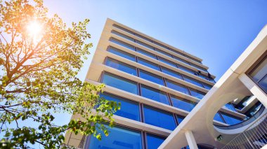 Yeşil çevresi olan bir ofis. Şirket binası karbondioksiti azaltır. Karbondioksiti azaltmak için ağaçlı sürdürülebilir cam ofis binası. Modern şehirde çevre dostu bir bina..