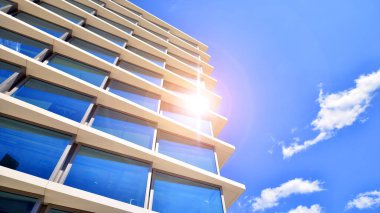 Şehir merkezindeki işletme bölgesi mimarisi. Mavi gökyüzüne ve güneş ışığına karşı cam yansıtıcı ofis binaları. Ekonomi, finans, iş faaliyeti konsepti. Soyut modern mimari parçası