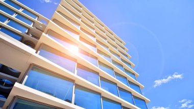 Şehir merkezindeki işletme bölgesi mimarisi. Mavi gökyüzüne ve güneş ışığına karşı cam yansıtıcı ofis binaları. Ekonomi, finans, iş faaliyeti konsepti. Soyut modern mimari parçası