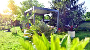 Güzel bahçesinde şık bahçe mobilyaları olan modern alüminyum pergola..