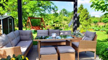 Güzel bahçesinde şık bahçe mobilyaları olan modern alüminyum pergola..