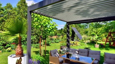Güzel bahçesinde şık bahçe mobilyaları olan modern alüminyum pergola..