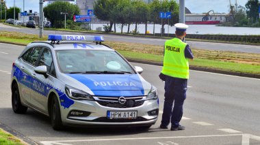 Szczecin, Polonya. 16 Temmuz 2025. Trafik polisi sokakta radar hızında silah tutuyor. Arka plan. 