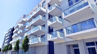 Yeşil yerleşim bölgesinde yeni daireleri olan modern bir yerleşim yeri. Çevre mimarisi. Yeşil ağaç ve yeni apartman. Doğanın ve modernliğin ahengi.