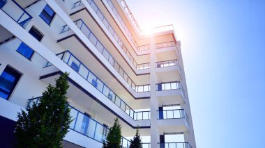 Yeşil yerleşim bölgesinde yeni daireleri olan modern bir yerleşim yeri. Çevre mimarisi. Yeşil ağaç ve yeni apartman. Doğanın ve modernliğin ahengi.