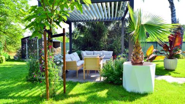 Güzel bahçesinde şık bahçe mobilyaları olan modern alüminyum pergola..
