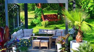 Güzel bahçesinde şık bahçe mobilyaları olan modern alüminyum pergola..