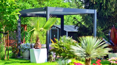Güzel bahçesinde şık bahçe mobilyaları olan modern alüminyum pergola..