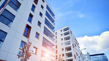 Mavi gökyüzü olan güneşli bir günde modern apartman binaları. Modern bir apartmanın ön cephesi. Modern konut binası kompleksi.