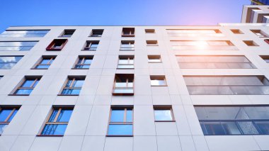 Mavi gökyüzü olan güneşli bir günde modern apartman binaları. Modern bir apartmanın ön cephesi. Modern konut binası kompleksi.