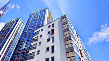 Çok katlı, modern bir apartmanın dış cephesi, pencereleri ve balkonları. Sonsuz cam cephe. Modern şehir yaşam bölgesi.