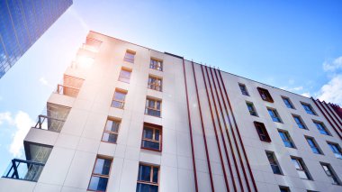 Mavi gökyüzü olan güneşli bir günde modern apartman binaları. Modern bir apartmanın ön cephesi. Modern konut binası kompleksi.