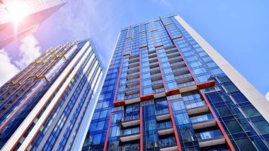 Çok katlı, modern bir apartmanın dış cephesi, pencereleri ve balkonları. Sonsuz cam cephe. Modern şehir yaşam bölgesi.