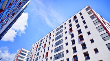 Mavi gökyüzü olan güneşli bir günde modern apartman binaları. Modern bir apartmanın ön cephesi. Modern konut binası kompleksi.