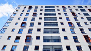 Mavi gökyüzü olan güneşli bir günde modern apartman binaları. Modern bir apartmanın ön cephesi. Modern konut binası kompleksi.