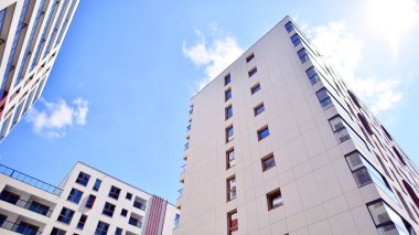 Mavi gökyüzü olan güneşli bir günde modern apartman binaları. Modern bir apartmanın ön cephesi. Modern konut binası kompleksi.