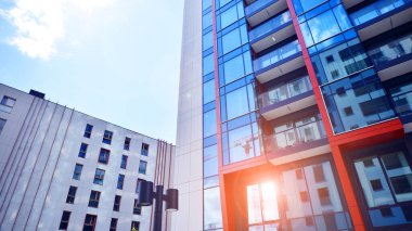 Çok katlı, modern bir apartmanın dış cephesi, pencereleri ve balkonları. Sonsuz cam cephe. Modern şehir yaşam bölgesi.