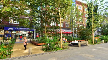 Warsaw, Poland. 21 September 2025. Chmielna in downton lined with granite slabs and planted with plants and shrubs street. City promenade during summer day. City architecture with shops and greenery.