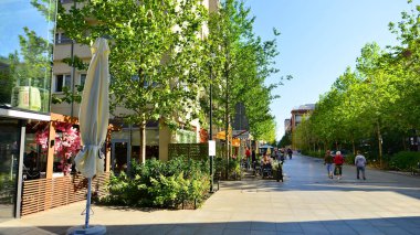 Warsaw, Poland. 21 September 2025. Chmielna in downton lined with granite slabs and planted with plants and shrubs street. City promenade during summer day. City architecture with shops and greenery.