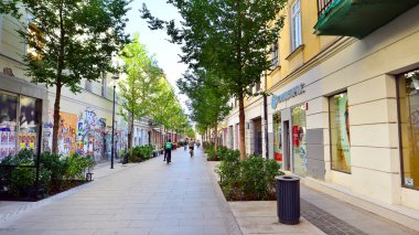 Warsaw, Poland. 21 September 2025. Chmielna in downton lined with granite slabs and planted with plants and shrubs street. City promenade during summer day. City architecture with shops and greenery.