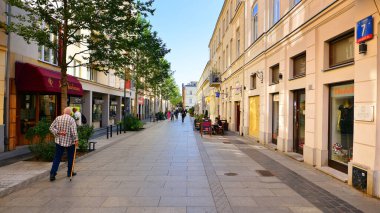Warsaw, Poland. 21 September 2025. Chmielna in downton lined with granite slabs and planted with plants and shrubs street. City promenade during summer day. City architecture with shops and greenery.
