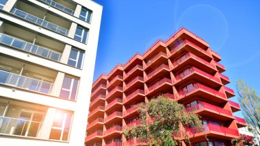 Bereketli yeşil ağaçlarla çevrili ve güneşli bir günde taze bitki örtüsüyle çevrili bir yerleşim yeri. Çağdaş mimari konut kompleksi yeşilliklerle çevrili.