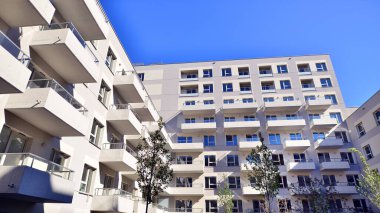 Bereketli yeşil ağaçlarla çevrili ve güneşli bir günde taze bitki örtüsüyle çevrili bir yerleşim yeri. Çağdaş mimari konut kompleksi yeşilliklerle çevrili.