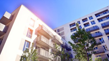 Bereketli yeşil ağaçlarla çevrili ve güneşli bir günde taze bitki örtüsüyle çevrili bir yerleşim yeri. Çağdaş mimari konut kompleksi yeşilliklerle çevrili.