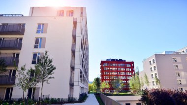 Bereketli yeşil ağaçlarla çevrili ve güneşli bir günde taze bitki örtüsüyle çevrili bir yerleşim yeri. Çağdaş mimari konut kompleksi yeşilliklerle çevrili.