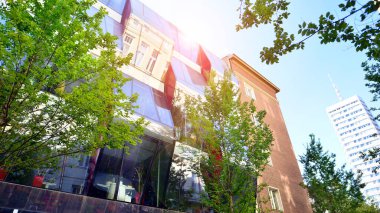 Etrafı yeşil ağaçlarla çevrili cam ofis binası. Çevre dostu ofis binası. Şehrin sürdürülebilir mimarisi ısı karbondioksit azaltıyor modern şehir çevresi.