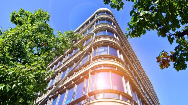 Etrafı yeşil ağaçlarla çevrili cam ofis binası. Çevre dostu ofis binası. Şehrin sürdürülebilir mimarisi ısı karbondioksit azaltıyor modern şehir çevresi.