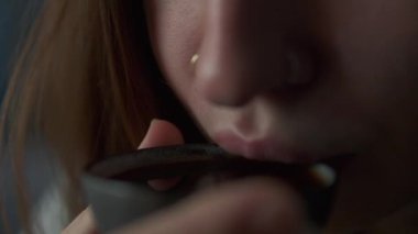 Güzel bir kız çay seremonisi sırasında çaydan hoşlanır. Dudaklara yakın çekim. Çay içen güzel bir kadın. Yavaş çekim