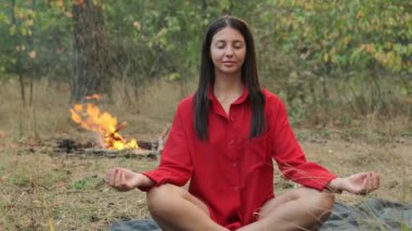 Sakin bir kadın zihinsel refah ve rahatlama için farkındalık meditasyonu yapıyor..