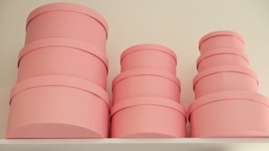 Yuvarlak pembe hediye kutuları beyaz bir rafa dizilmiş minimalist ve düzenli bir şekilde..
