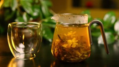 Çay yaprakları, cam bir çaydanlığın içinde yavaşça kıvrılarak sıcak bir yuva ortamında güzel bir dans yaratır..