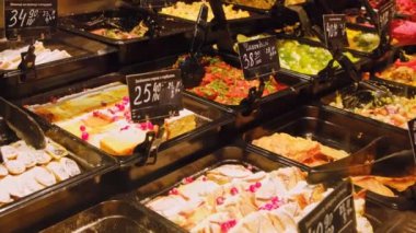 Pasta çeşitleri, krepler, etiketli ve fiyatlı güveçler, bir fırın vitrinindeki tepsilerde düzgünce düzenlenmiştir..