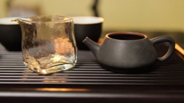 Çin çay seremonisi sırasında bir kil çaydanlığa su dökülür. Geleneksel çay tepsisinin üzerinde çay tepsisi bulunur..