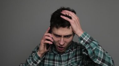 Mümkün değil, olamaz. Şok olmuş bir adam telefondaki sosyal medyada haber okurken şaşkınlık içinde akıllı telefon mesajına şaşırmış. Yüksek kalite 4k görüntü