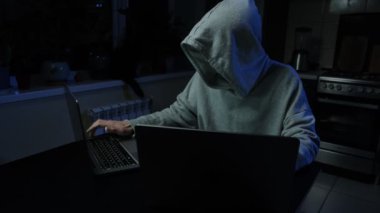 Tanınmayan hacker adam ellerini uzatıyor ve dizüstü bilgisayarda klavye yazmaya başlıyor. Yüksek kalite 4k görüntü