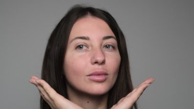 Yumuşak dudaklarını, temiz tenini ve yanağına dokunan nazik elini vurgulayan, doğal güzelliği somutlaştıran bir kadın yüzü. Yüksek kalite 4k görüntü