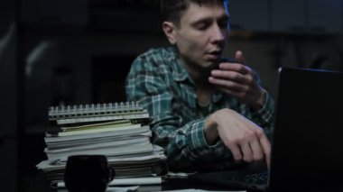 Yorgun genç bir öğrenci ya da serbest çalışan biri gece geç saatlerde iş yerinde uyuyakalır. Uzaktan çalışmaktan ya da ders çalışmaktan yorgun düşmüştür. Yüksek kalite 4k görüntü