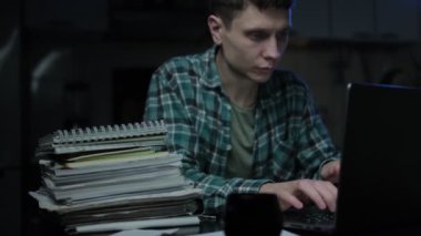 Odaklanmış ve konsantre olmuş öğrenci internet sitesinden öğreniyor. Merkez büroda uzaktan çalışan genç bir adam, iş belgelerine not alıyor, dizüstü bilgisayarına bakıyor.