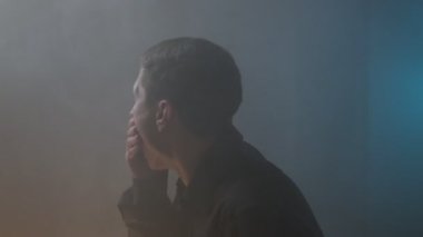 Duman dolu bir odada bir adam ağzını kapatıyor, yangın yüzünden öksürüyor ve boğuluyor, çıkış yolu bulamıyor..