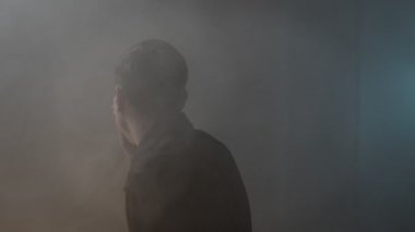 Yangın sırasında dumanla dolu bir odada kapana kısılmış bir adam nefes almaya çalışırken ağzını kapatıyor ve acil yardıma ihtiyacı olan bir çıkış yolu arıyor..