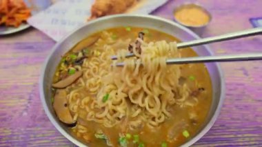 Mantarlı ramen eriştesi ve taze soğan çorbası. Yemek çubuklarıyla çalınmış..