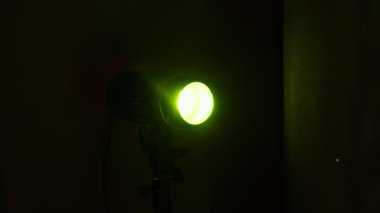 Parlayan toz parçacıkları havada süzülürken karanlık bir odada parlayan yeşil bir spot ışığı sinematik bir atmosfer yaratır..