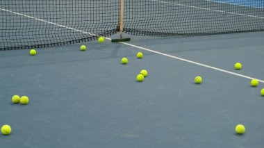 Bir tenis topunun antrenman sırasında ağa çarpması, spor hazırlık, hassasiyet ve oyun tekniğini sembolize eder.