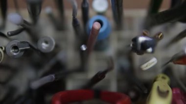 Farklı sapları olan çeşitli metal aletlerden oluşan bir koleksiyon, birbirine yakın bir şekilde dizilmiş, sığ bir alan derinliği olan detaylı bir yakın plan gösterimi, işçiliği ve hassasiyeti vurgulayan