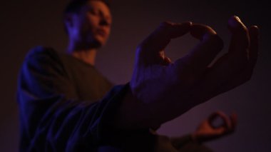 Huysuz bir ışık, farkındalığı, iç huzuru ve ruhsal dengeyi temsil eden meditasyon amaçlı bir el hareketinin yakın çekimi.