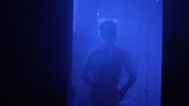 Havlu giymiş bir adam aynada saçını düzeltir. Duş aldıktan sonra düşüncelere dalır. Evde sakin ve içe dönük bir akşam geçirir.